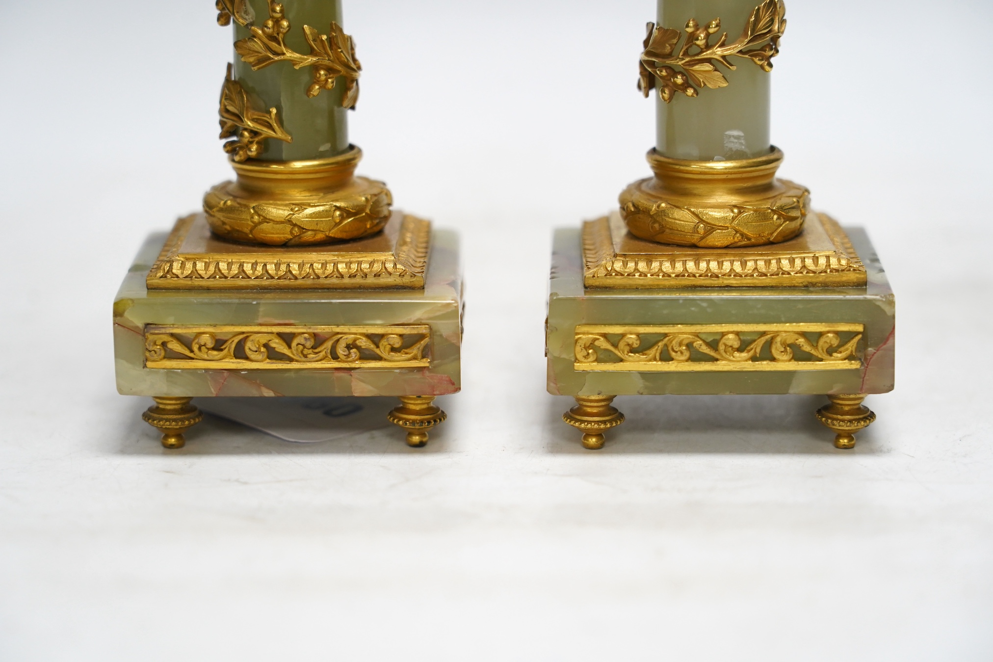 A pair of early 20th century French ormolu mounted onyx candlesticks, 20cm high